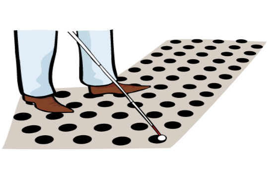 Füße auf einem Bodenleitsystem für blinde Menschen.