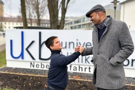 Herr John und Herr Sönksen begrüßen sich mit Handschlag vor dem UKB.