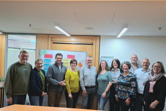 Auf dem Bild sind Kolleg*innen der EAA sowie der DRV aufgestellt vor einer Flipchart-Tafel zu sehen.