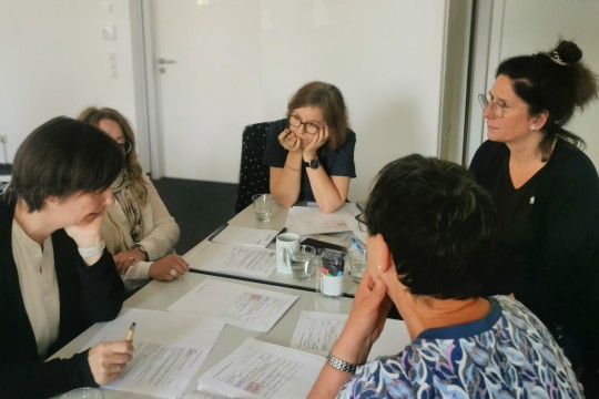 Zu sehen sind fünf Fachberatende der EAA während einer Gruppenarbeit