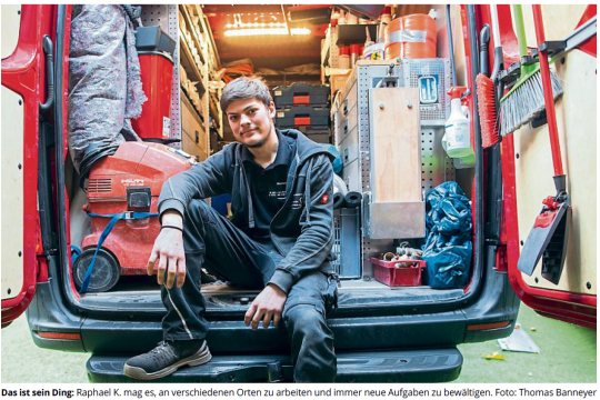 Raphael sitzt locker im vollgepackten Laderaum seines Montageautos. 