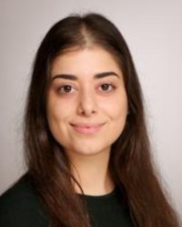 Potrait von Frau Ghafur-Topaloglu: Sie hat ihre schwarzen Haare zu einem Zopf nach hinten gebunden. Sie trägt eine weiße Bluse.