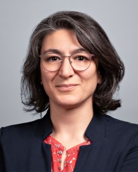 Potrait von Frau Yildiz: Sie hat schulterlange dunkel braune Haare und trägt einen beschfarbende Jacke. 