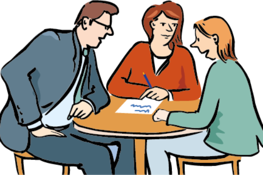 2 Frauen und ein Mann sitzen an einem runden Tisch und unterhalten sich. 